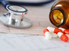 pills and stethoscope sitting on desk