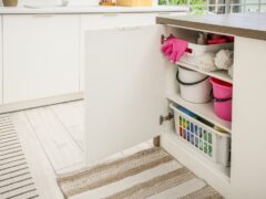 Cleaning supplies stored in a cabinet.